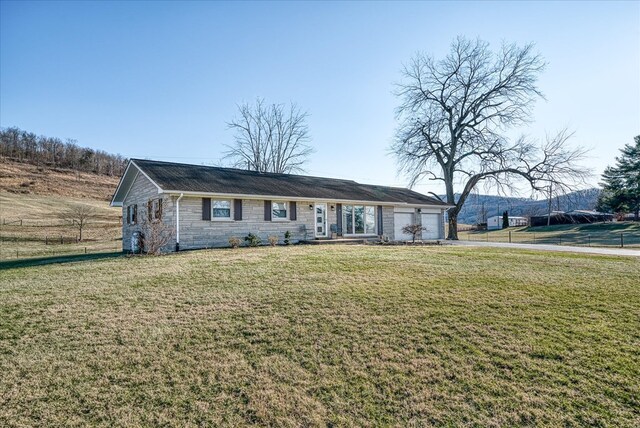 ranch-style house with stone siding, a front lawn, and an attached garage