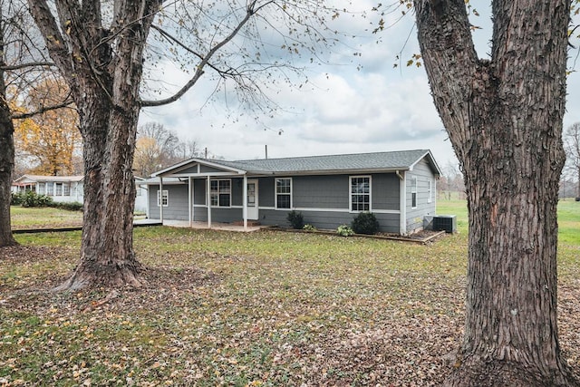 view of front of house with central AC and a front yard