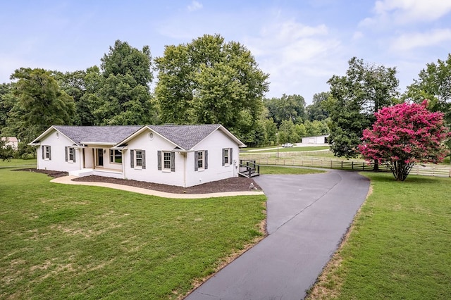 view of front facade featuring a front yard and fence