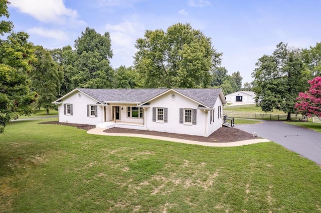 single story home featuring driveway, fence, a porch, and a front yard