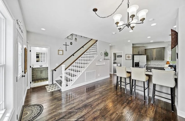 kitchen featuring stainless steel fridge, visible vents, light countertops, and dark wood-style flooring