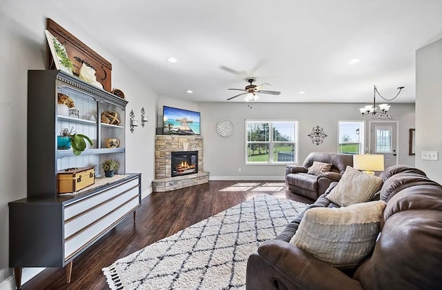 living room with dark wood-style floors, a fireplace, recessed lighting, baseboards, and ceiling fan with notable chandelier