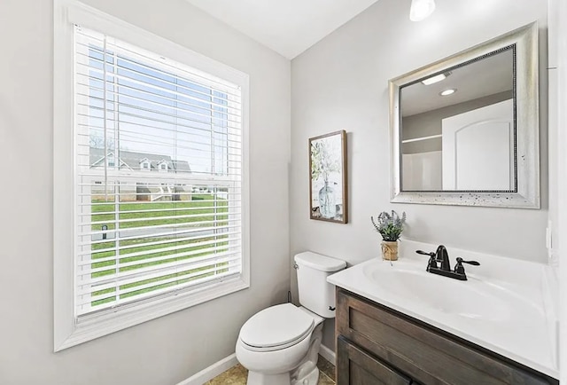 bathroom featuring a wealth of natural light, baseboards, vanity, and toilet