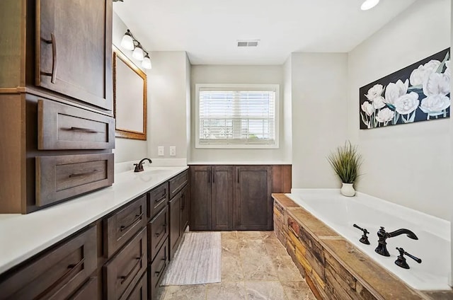 full bathroom with visible vents, a bath, and vanity