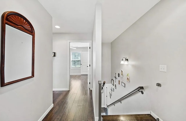 corridor with dark wood finished floors and baseboards