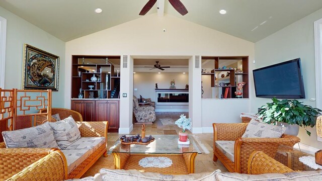 living area with vaulted ceiling, built in shelves, a fireplace, and a ceiling fan