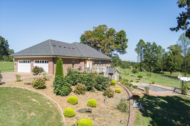 view of front of house with brick siding, a shingled roof, a garage, driveway, and a front lawn