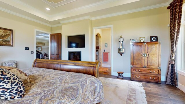 bedroom with dark wood-style floors, arched walkways, crown molding, and baseboards