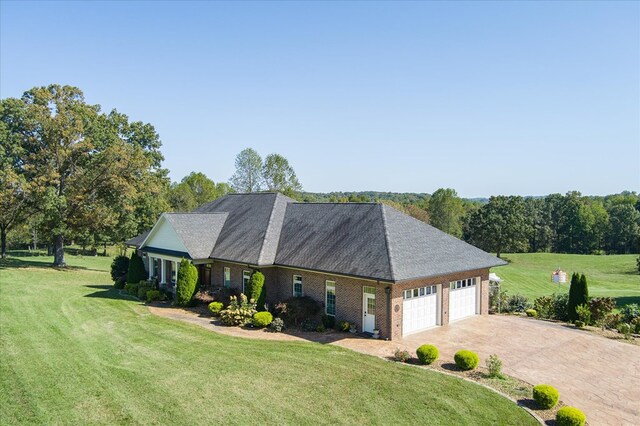 view of front of property featuring an attached garage, brick siding, a shingled roof, driveway, and a front lawn