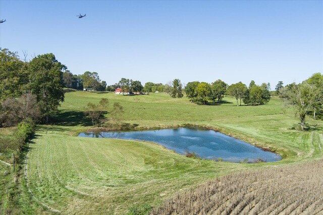 exterior space with a water view, a rural view, and a yard