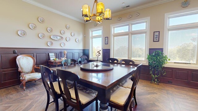 dining room featuring a wainscoted wall, plenty of natural light, visible vents, and crown molding