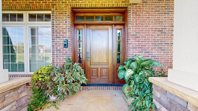 entrance to property featuring brick siding