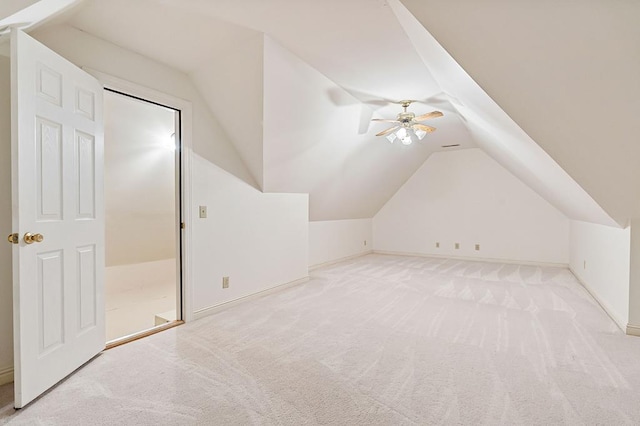 additional living space featuring light carpet, ceiling fan, baseboards, and vaulted ceiling