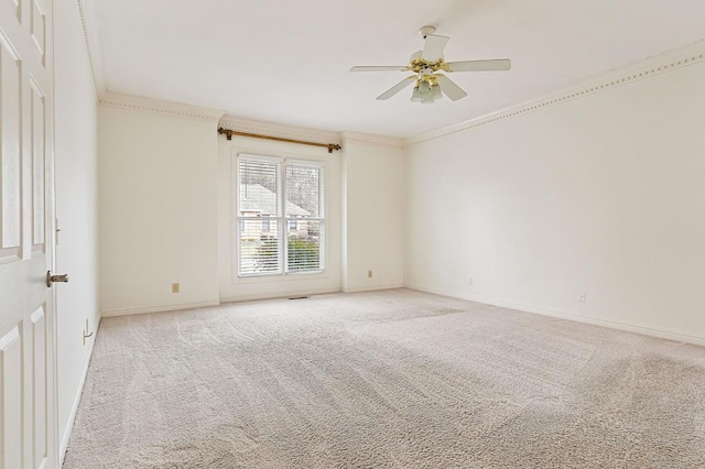 empty room with a ceiling fan, baseboards, crown molding, and light colored carpet