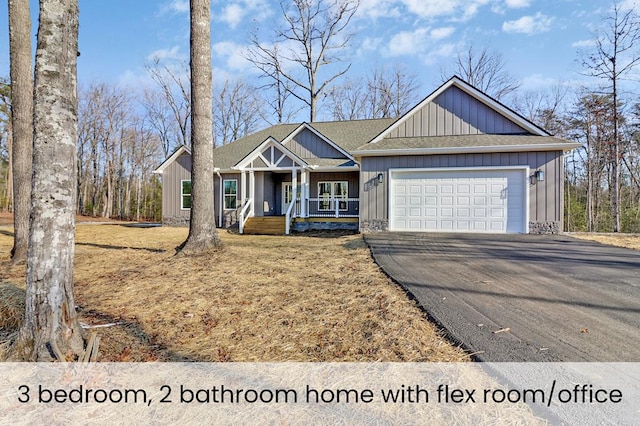 view of front facade featuring aphalt driveway, a shingled roof, covered porch, an attached garage, and board and batten siding