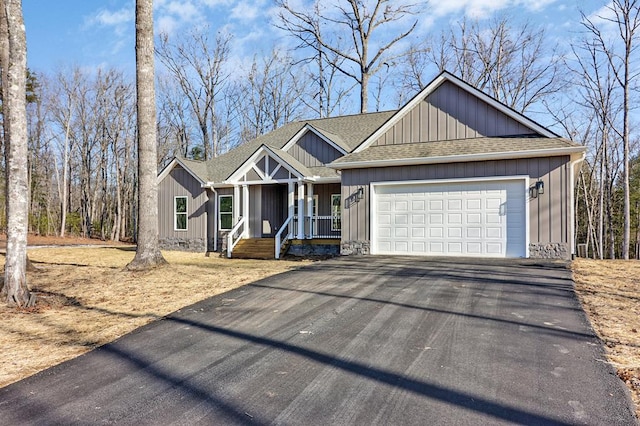 view of front of house with a garage, driveway, and roof with shingles