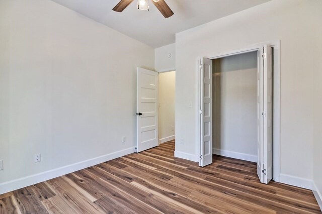 unfurnished bedroom with wood finished floors, a ceiling fan, and baseboards