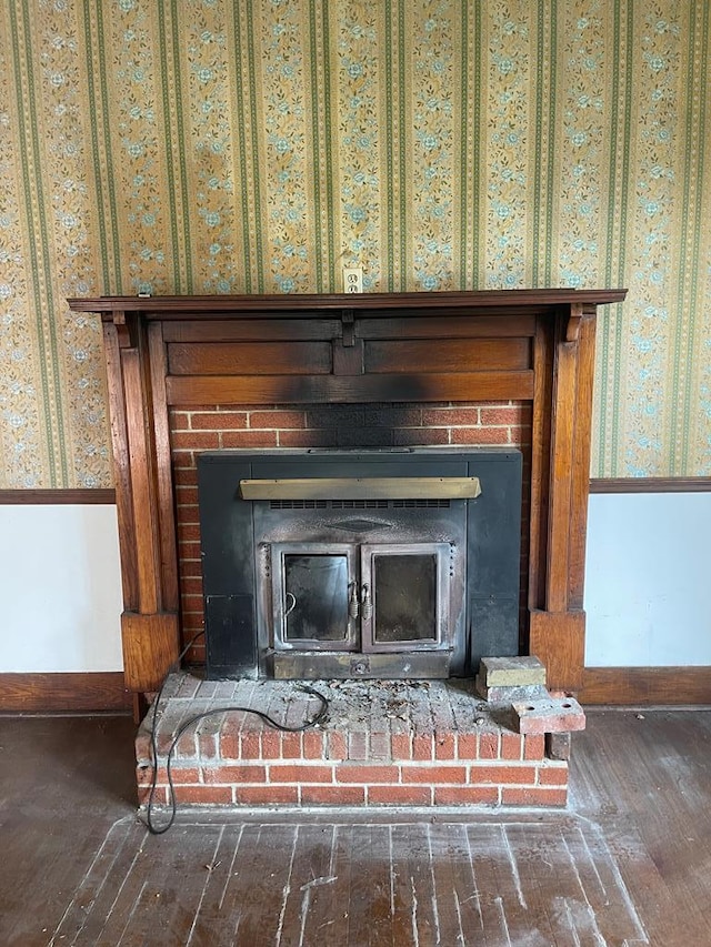 interior details with wallpapered walls, a fireplace, baseboards, and wood finished floors