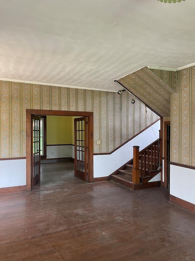 empty room with wallpapered walls, baseboards, stairway, and dark wood finished floors