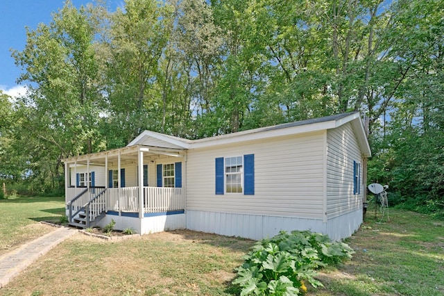 manufactured / mobile home with covered porch and a front lawn