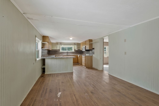 kitchen with a peninsula, light wood-type flooring, light brown cabinets, open shelves, and backsplash