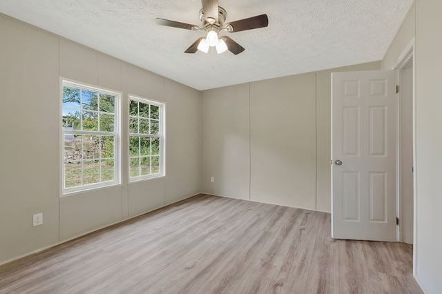 unfurnished room featuring a textured ceiling, ceiling fan, and light wood-type flooring