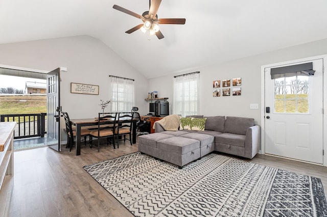 living area featuring lofted ceiling, wood finished floors, and a ceiling fan