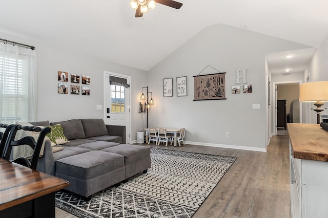 living area with lofted ceiling, baseboards, a ceiling fan, and wood finished floors