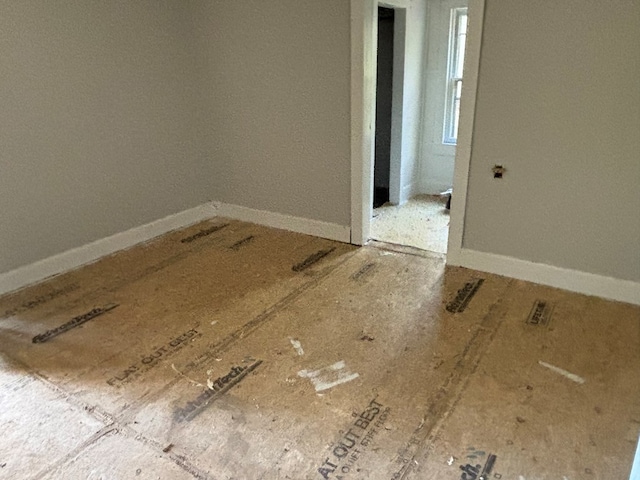 unfurnished room with baseboards