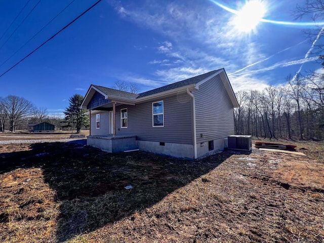 view of home's exterior with crawl space and cooling unit