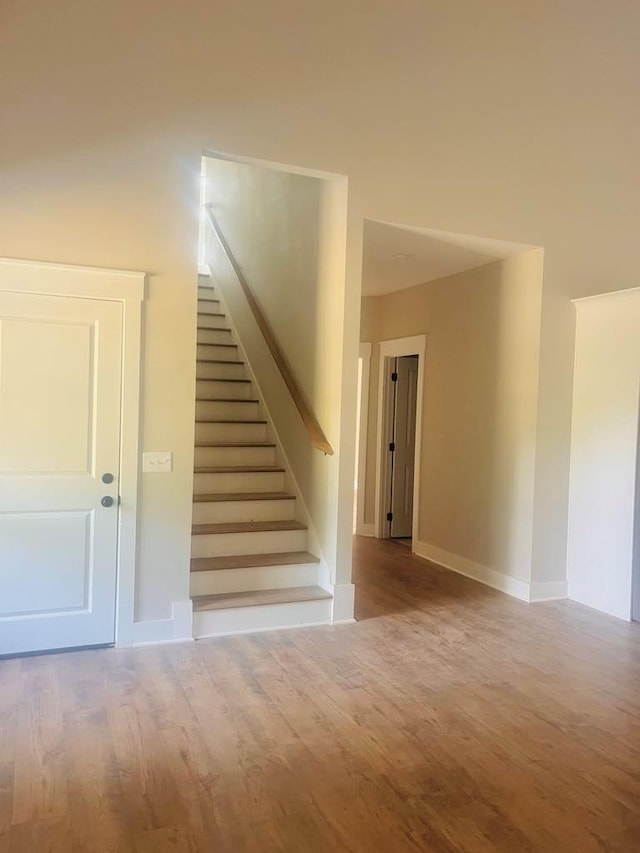 stairs featuring wood finished floors and baseboards