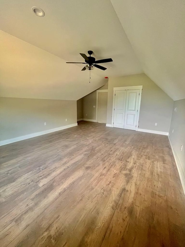 additional living space featuring lofted ceiling, baseboards, and wood finished floors