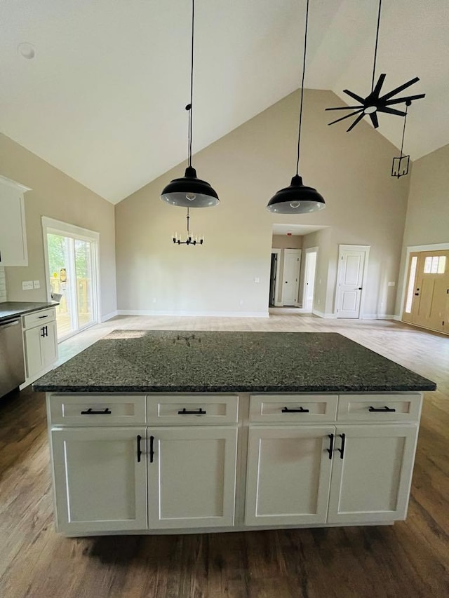 kitchen with dark stone counters, open floor plan, and white cabinetry