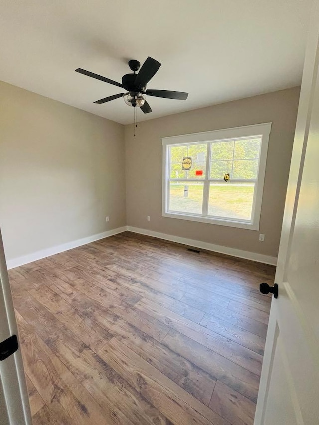 unfurnished room with light wood-style flooring, visible vents, baseboards, and a ceiling fan