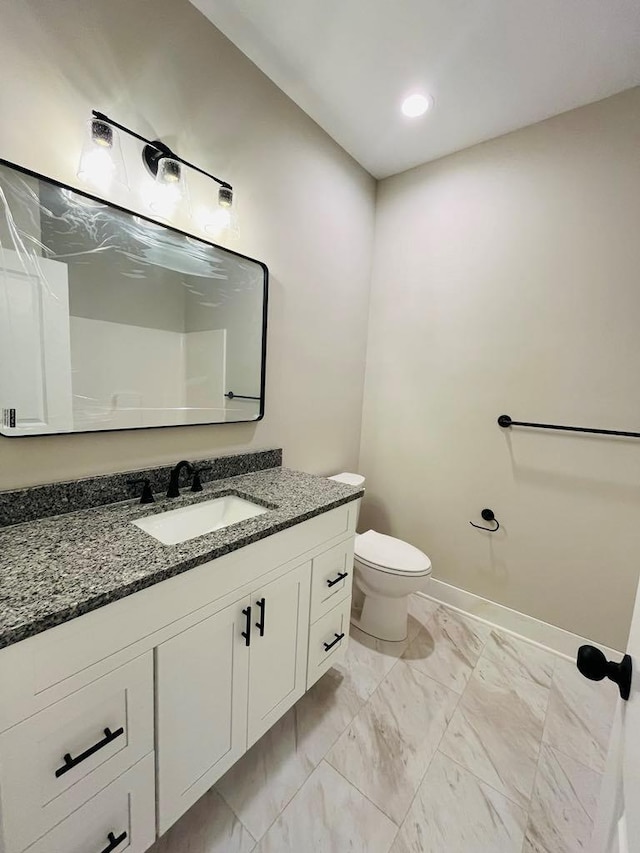 bathroom featuring toilet, marble finish floor, baseboards, and vanity