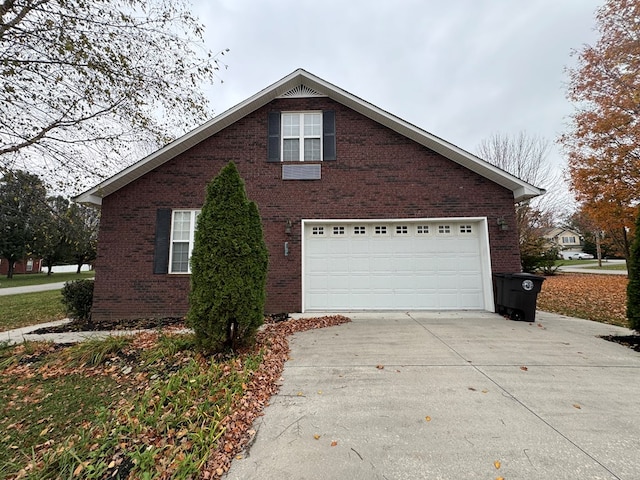 view of property exterior with driveway, a garage, and brick siding