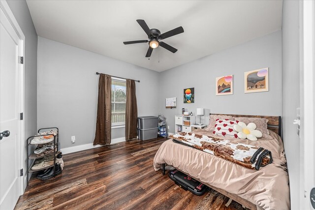 bedroom featuring baseboards, dark wood finished floors, and a ceiling fan