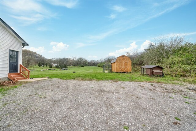 view of yard featuring entry steps, a storage shed, and an outbuilding