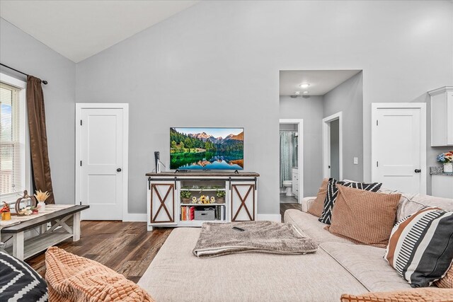 living room with high vaulted ceiling, dark wood-style flooring, and baseboards