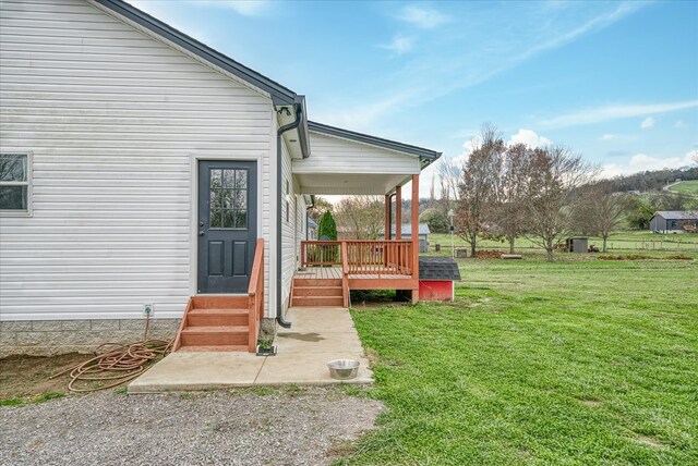 entrance to property featuring a yard and a wooden deck