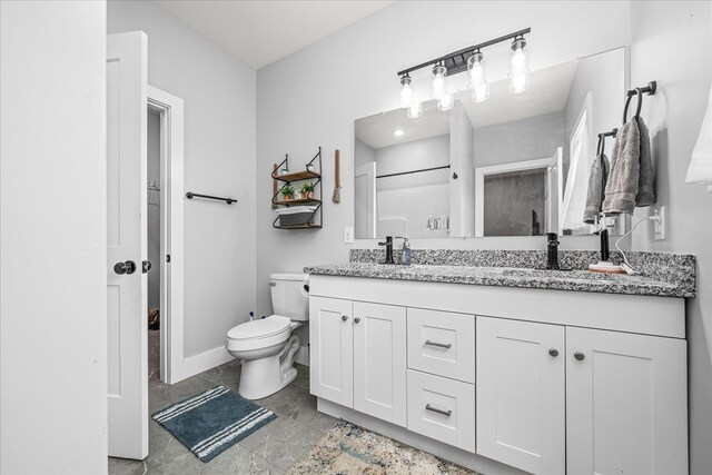 full bath with toilet, a sink, baseboards, and double vanity