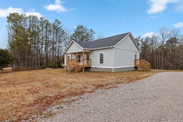 view of front of home with crawl space, covered porch, and a shingled roof