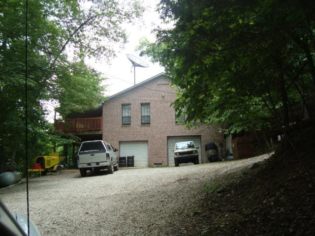 view of home's exterior with gravel driveway and an attached garage