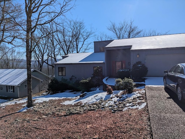 view of snow covered exterior featuring an attached garage