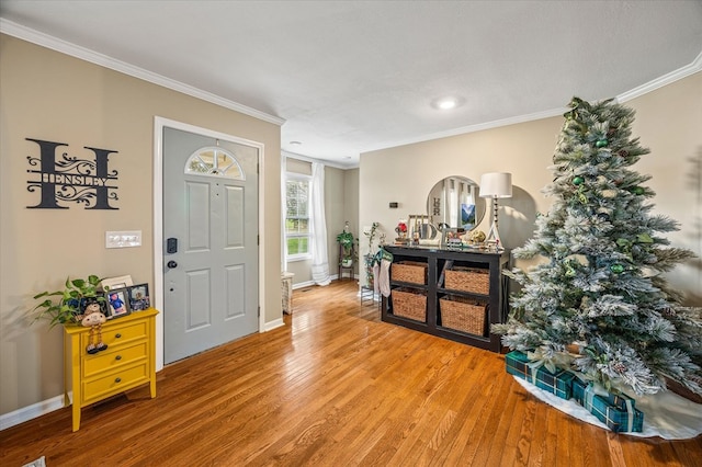 entryway with ornamental molding, baseboards, and wood finished floors