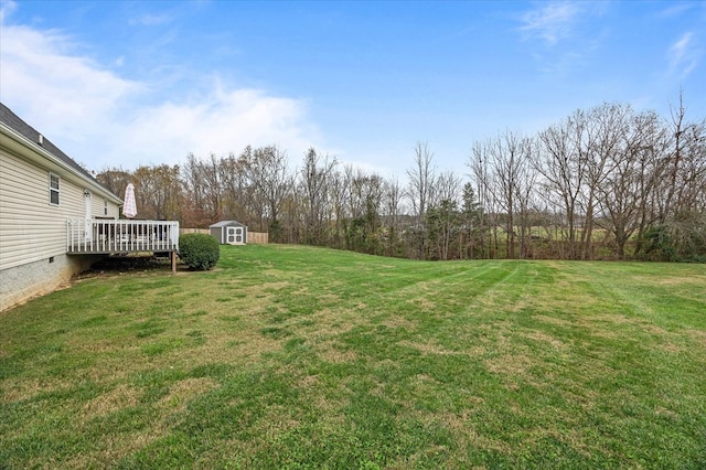 view of yard with a deck, a shed, and an outdoor structure