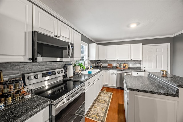 kitchen featuring stainless steel appliances, a sink, white cabinets, ornamental molding, and dark wood finished floors