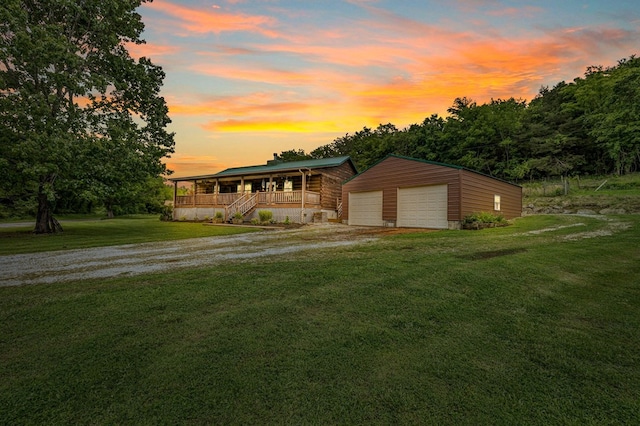 view of front of home featuring a garage, a front yard, an outdoor structure, and driveway