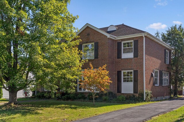 view of front of home featuring a front yard and brick siding