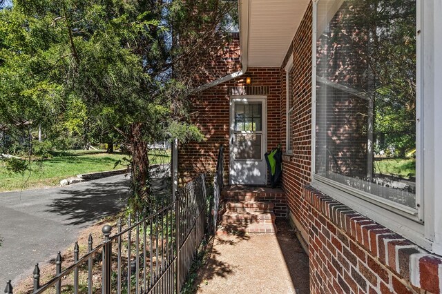 view of side of property featuring fence and brick siding